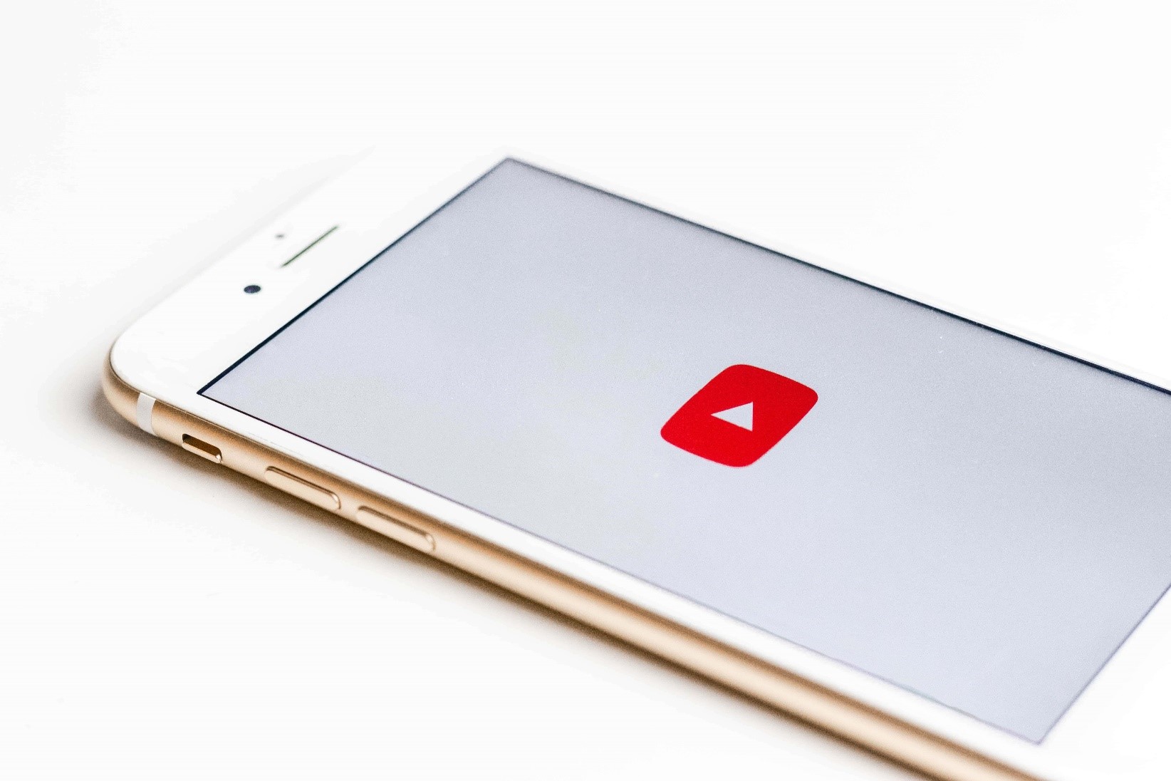 An iPhone with the YouTube app open, lying on a white background.